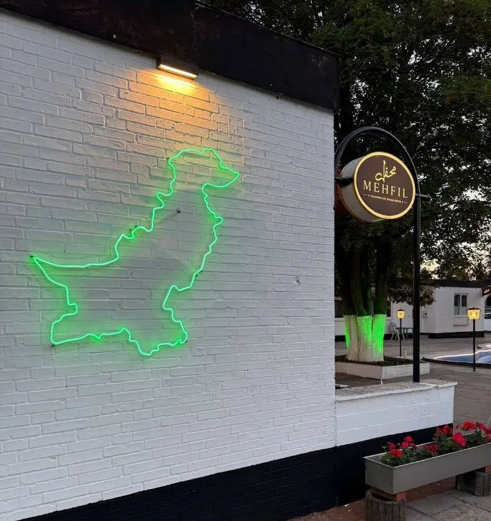 Mehfil von außen mit leuchtender Pakistan-Karte in Neon
